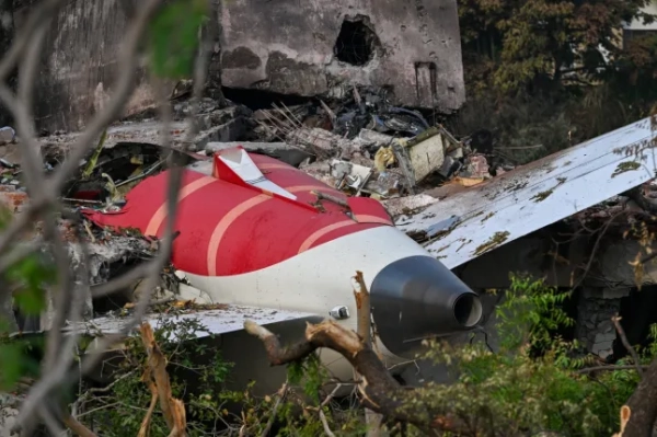 Уламки, що показують хвостову частину Boeing 787-8 авіакомпанії Air India, зображені в житловому районі поблизу аеропорту Ахмедабада 14 червня 2025 року після того, як літак, що виконував рейс 171, розбився невдовзі після зльоту 12 червня. 13 червня слідчі виявили чорну скриньку-самовивідувач на місці аварії пасажирського літака, що прямував до Лондона, який врізався в житловий район індійського міста Ахмедабад, вбивши щонайменше 265 людей на борту та на землі. (Фото Punit PARANJPE / AFP) (Фото PUNIT PARANJPE/AFP via Getty Images)
