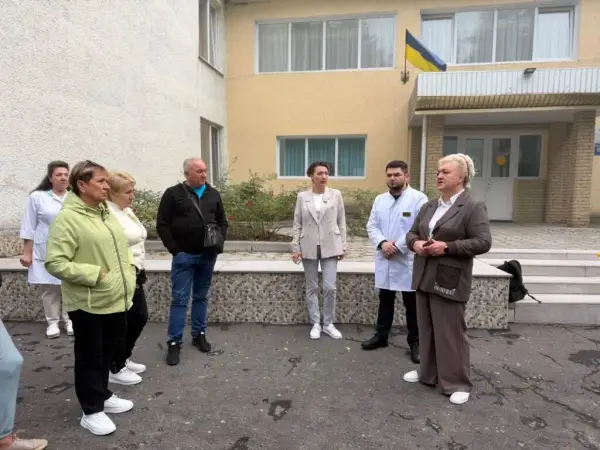 Люди перед двоповерховою будівлею