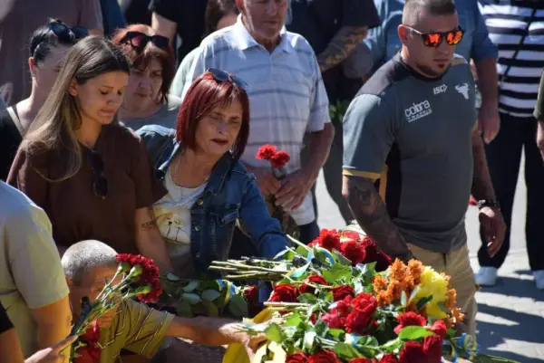 Люди кладуть квіти на домовину