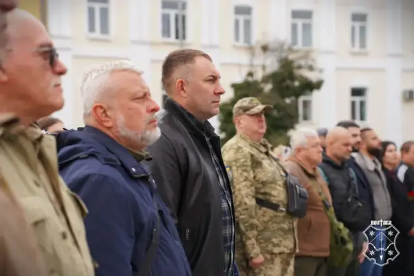 чоловіки стоять на майданчику біля прапора